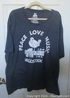 Front view of navy blue Woodstock T-shirt showing full graphic and text.