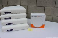 Four stacked Purple Pillow bed pillows and a boxed Circadian Optics lamp