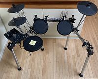 Front view showing entire Alesis electronic drum kit with module, stand, drum and cymbal pads