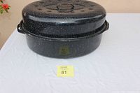 Closed view of the enamel roaster pan with lid on a white cloth background.