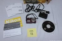Nikon COOLPIX S550 camera and all accessories including charger, cables, software CD, manuals, and original box arranged on white surface.