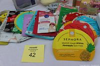 Photo showing an assortment of facial sheet masks including brands like Sephora, Yes To, TonyMoly, and Miss Spa on a tabletop.