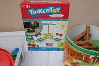 Close-up of Tinker Toys box with 84 pieces and part of the log cabin container visible