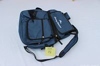 Full view of the blue Tommy Bahama backpack showing multiple zippered compartments and shoulder straps.