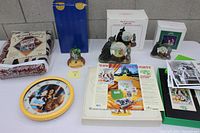 Photo showing entire collection including boxed musical water globes, figurines on display, boxed collector's set with script and photos, throw blanket, wall clock, and loose photos and VHS tapes.