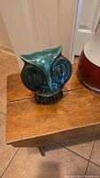 Photo of Blue Mountain Pottery owl piggy bank on wooden surface showing green and blue glaze with no visible damage.