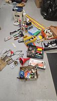 Wide view of the lot showing various tools, lubricants, measuring devices, and parts arranged on floor