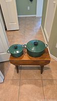 Both green enamel cast iron casserole dishes, 18cm and 24cm, front view