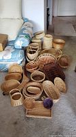 Overall view of diverse collection of baskets and market bags arranged on floor.