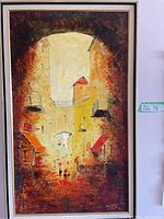 Full view of the framed cityscape painting with warm vivid colors and urban street scene under an archway.