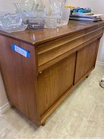 Front view of teak sideboard with two drawers and sliding doors