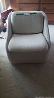 Front view of the vintage Wovenbyrd barrel chair with cushion in place, showing the textured light fabric upholstery.