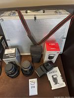 Overview showing two lens boxes, two lenses, flash box, flash unit, carrying case and strap