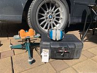 Shows the lot next to a BMW car tire with the rest support stand, ear muffs placed on the safe.