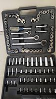Full view of the socket set in its black plastic case showing sockets, ratchets, extensions, and screwdriver handle