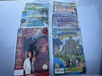 Photo of assorted DC comic books including Flash TV Special, Superman, Star Squadron, Alpha Centurion and others laid out to show covers