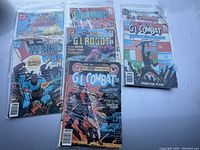 Five assorted vintage war-themed comics bagged in clear sleeves, including G.I. Combat, G.I. Robot, and Weird War Tales