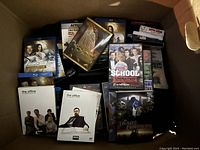 Box with mix of DVDs and BluRay movies featuring The Office, Transformers, Iron Man, Terminator, Star Trek and others.