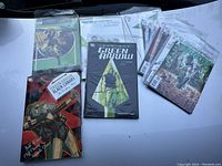 Overview of multiple Green Arrow graphic novels and comics placed on a white surface including a novel by Kevin J. Taylor, a Black Canary Wedding Album, and several issue comics.