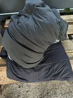 Photo of king size weighted blanket folded on top of its cover on wooden surface.