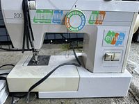 Front view of white Elnita 200 sewing machine showing stitch selection dial and logo.