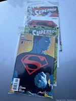 Three Superboy comic books in plastic sleeves with visible front covers.