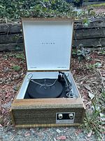 Open vintage Viking turntable case showing black platter, two control knobs, and woodgrain and fabric textured exterior.