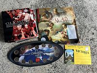 Photo showing the entire lot with the quarter set display, Olympic Hockey Heroes card book, religious themed book, and vintage postcards.