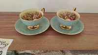 Two matching teacup and saucer sets, front view
