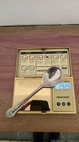 Sterling silver spoon on digital scale showing weight of 29.25 grams