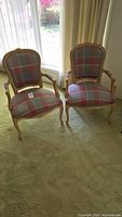 Two matching armchairs side by side near window, showing full front and overall condition.