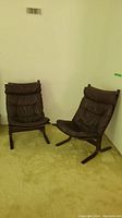 Pair of brown leather Siesta lounge chairs against white wall