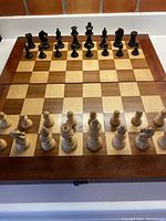 Full view of chessboard with all chess pieces arranged in starting position, shows wood grain and board design