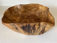 Angle view showing overall shape, texture, and organic form of the rustic wood bowl