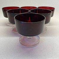 Front and angled view showing the deep ruby red glass bowls with clear stems and feet, set of six visible, total eight in lot.