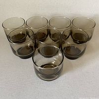 Group of 8 smoky brown scotch glasses arranged in a cluster showing glass tint and thickness.