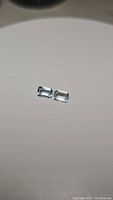 Pair of natural emerald cut sky blue topaz gemstones, showing light blue color and rectangular cut.