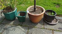 Four ceramic pots arranged outdoors on a concrete surface to show sizes and general condition
