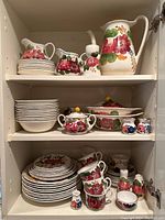 Cabinet view of entire dinnerware set showing multiple plates, bowls, cups, and serving pieces