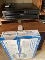 Onkyo CD player on shelf, wooden case speakers, LiteOn DVD recorder box in front