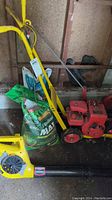 Gasoline edger, electric leaf blower, and Scotts Green Max Lawn Food in storage
