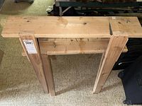 Overhead view of one wooden sawhorse showing flat top and cross brace between legs.