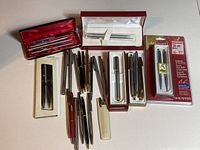 Full overview of all pens and pen sets included in lot showing various brands and packaging conditions
