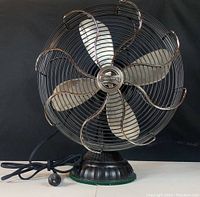 Front view of the Casablanca fan showing metal blades and protective grille with copper accents.
