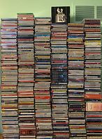 Four stacks of CDs with various artists and genres visible, including The Irish Tenors, John McDermitt, Johnny Cash, Haydn Symphonies.