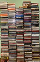 Full overview of stacked CDs showing titles and variety of artists and genres in jewel cases.