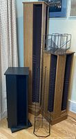 Photo showing entire lot of four CD towers including tall brown wood tower, smaller brown tower, black rotating tower, and standing wire tower.