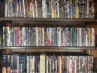 Wide shot showing many DVD and Blu-Ray cases lined up on shelves, showcasing a variety of titles and genres.