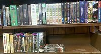 Shelf of assorted DVDs and Blu-Rays including The Pacific, Stranger Things, Deadwood, Game of Thrones, and more.