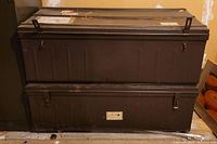 Two stacked metal trunks showing condition and size of each item